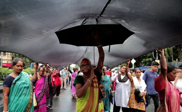 Members of women's rights organizations and Trinamool Congress activists shout slogans during a protest march with a giant black cloth, over sexual violence against women in the northeastern state of Manipur and the ongoing conflict between two ethnic groups, Kukis and Meiteis, in Kolkata, Eastern India, 24 July 2023. The Supreme Court of India on 20 July took suo motu cognizance after a viral video of naked women being paraded and sexually assaulted in the violence-hit northeastern state of Manipur, and termed it 'deeply disturbing' and the “grossest violation of constitutional and human rights”. At least 130 people have been killed, and more than 60,000 were displaced as ethnic violence continues since the clashes broke out between two ethnic groups in May in the state of Manipur. (Photo by Piyal Adhikary/EPA)