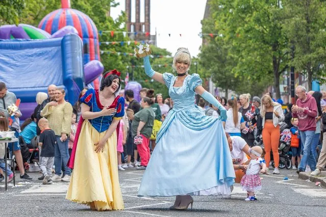 Two women dressed in Snow-White and Cinderella take part in the celebrations for the Britain's Queen Elizabeth II's platinum jubilee on Donegall Pass in Belfast, Northern Ireland, on June 3, 2022. Britain's first and very likely only Platinum Jubilee is being celebrated with street parties, pop concerts and parades including a huge public pageant involving 6,000 performers. (Photo by Paul Faith/AFP Photo)