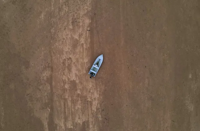 This aerial photo shows a boat on the dry riverbed of the Pahang river in Chenor, Malaysia's Pahang state, on August 10, 2023. (Photo by Mohd Rasfan/AFP Photo)