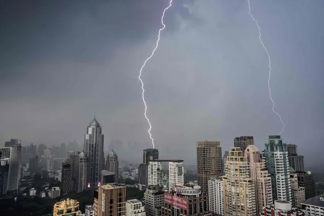 Lightning bolts strike buildings during a thunderstorm in Bangkok on May 3, 2021. (Photo by Mladen Antonov/AFP Photo)