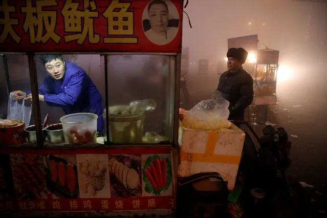 A street food vendor prepares food for customers as heavy smog blankets Shengfang, in Hebei province, on an extremely polluted day with red alert issued, China December 19, 2016. (Photo by Damir Sagolj/Reuters)