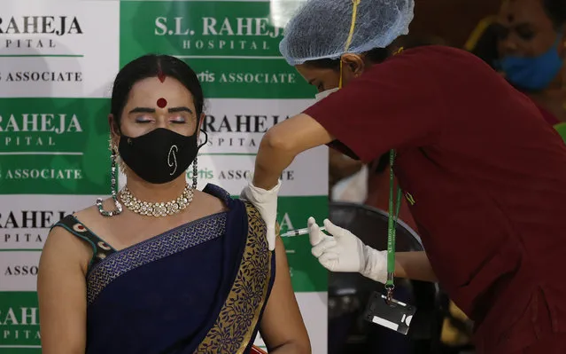 A health worker administers the Covishield vaccine against the coronavirus at a vaccination program for members of the transgender community in Mumbai, India, Sunday, June 20, 2021. (Photo by Rafiq Maqbool/AP Photo)