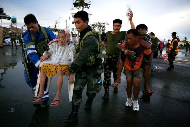 An elderly woman and an injured man are carried to a waiting C130 aircraft during the evacuation of hundreds of survivors of Typhoon Haiyan on Tuesday in Tacloban. (Photo by Paula Bronstein/Getty Images)