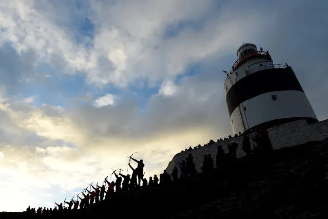 Archers fire arrows into the sea as part of a Claiming of the Waters tradition at the 800-year-old Hook Head lighthouse in Hook Head, Ireland January 1, 2017. (Photo by Clodagh Kilcoyne/Reuters)