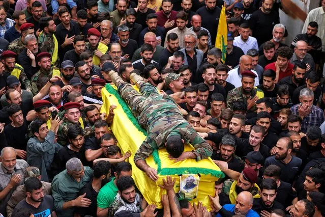 Nazih, son of Hezbollah member, Mounir Youssef Achour, who was killed in southern Lebanon amidst tension between Israel and Hezbollah, lies on top of his father's coffin as he mourns him during his funeral, in Chaqra, Lebanon on October 30, 2023. (Photo by Zohra Bensemra/Reuters)