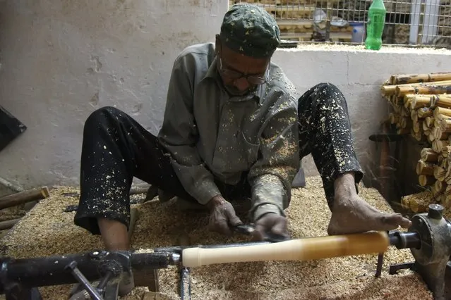 In this photograph taken on December 14, 2016, an Indian craftsman works on unfinished cricket bats in a factory in Meerut, some 70 kms north- east of New Delhi. As Indian factory worker Jitender Singh carves out another big- hitting slab of thick willow he insists MCC proposals to limit the size of cricket bats won' t tame Twenty20 marauders. “I don' t think the thickness matters. It' s more about the balance of the bat and the talent of the batsman”, says Singh, who has made bats for many stars, including South Africa's AB de Villiers. The World Cricket committee of the MCC, the guardians of the game, recommended in December 2016 that limitations be placed on the width and depth of bats because it had become too easy to smash fours and sixes. (Photo by Dominique Faget/AFP Photo)