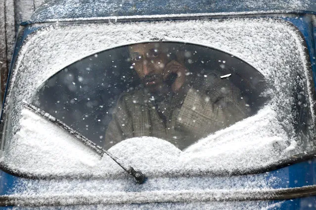 An auto-rickshaw driver looks out from the snow-covered windshield of his vehicle as the fresh snow falls in Srinagar, Indian controlled Kashmir, Friday, January 4, 2019. Snowfall in the Indian portion of Kashmir has disrupted air traffic, and road traffic between Srinagar and Jammu, the summer and winter capitals of India's Jammu-Kashmir state, according to news reports. (Photo by Dar Yasin/AP Photo)