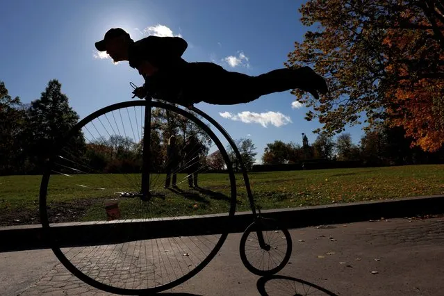 A participant wearing a historical costume rides his high-wheel bicycle during the annual penny farthing race in Prague, Czech Republic on November 4, 2023. (Photo by David W. Cerny/Reuters)