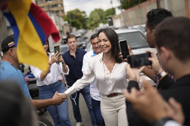 Supporters greet opposition presidential hopeful Maria Corina Machado as she arrives at a polling station to cast her ballot during the opposition primary election in Caracas, Venezuela, Sunday, October 22, 2023. The opposition will pick one candidate to challenge President Nicolás Maduro in 2024 presidential elections. (Photo by Matias Delacroix/AP Photo)