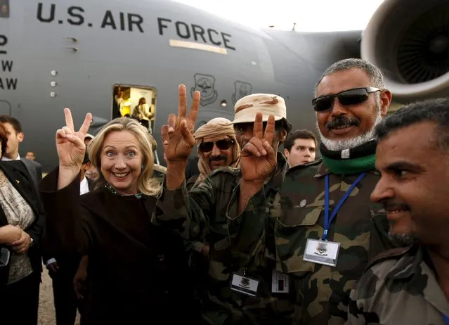 U.S. Secretary of State Hillary Clinton (C) gestures with Libyan soldiers upon her departure from Tripoli in Libya, in this October 18, 2011 file photo. (Photo by Kevin Lamarque/Reuters)