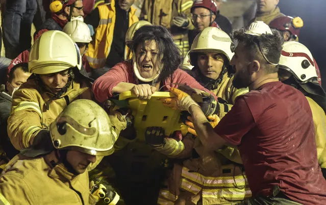 A woman reacts after rescue workers had pulled her out the rubble of an eight-story building which collapsed in Istanbul, Wednesday, February 6, 2019. The eight-story building collapsed, killing at least two people and trapping several others inside the rubble, Turkish officials said. The building had 43 people living in 14 apartments, with a street-level ground floor and seven higher floors, Istanbul Gov. Ali Yerlikaya said, adding that the top three floors had been built illegally. (Photo by DHA via AP)
