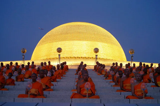 Buddhist monks pray at the Wat Phra Dhammakaya temple during a ceremony to commemorate Makha Bucha Day outside Bangkok, Thailand on February 19, 2018. Makha Bucha or Magha Puja, also known as the day of the Fourfold Assembly, is one of Buddhism's holiest days, celebrated on the full moon night of the third lunar month to commemorate the day that Lord Buddha gave the first sermon on the essence of Buddhism to his ordained 1,250 enlightened monks, who all assembled spontaneously, without an appointment. (Photo by Soe Zeya Tun/Reuters)