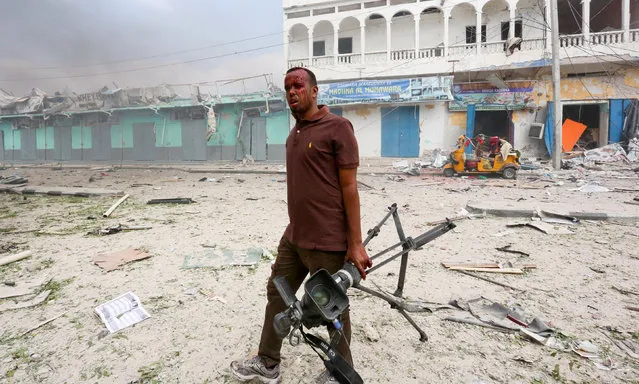 Somali Freelance journalist Mohamed Guray holds his camera after he was injured in a secondary explosion in front of Dayah hotel in Somalia's capital Mogadishu, January 25, 2017. (Photo by Feisal Omar/Reuters)