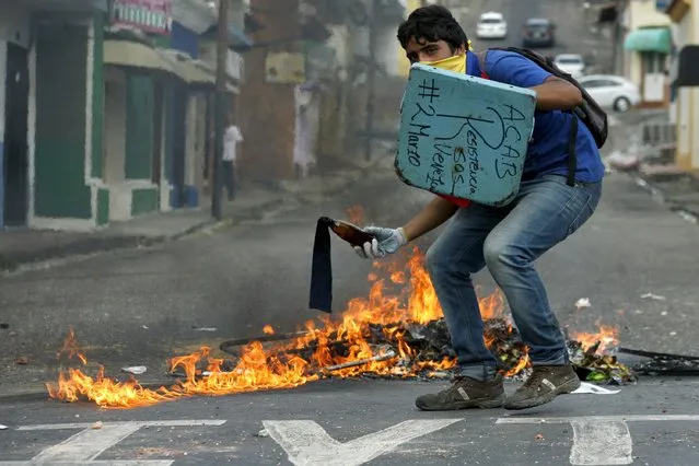 A student demonstrator prepares to throws a Molotov cocktail as they clash with the police during  a protest against President Nicolas Maduro's government in San Cristobal, Venezuela March 2, 2016. (Photo by Carlos Eduardo Ramirez/Reuters)
