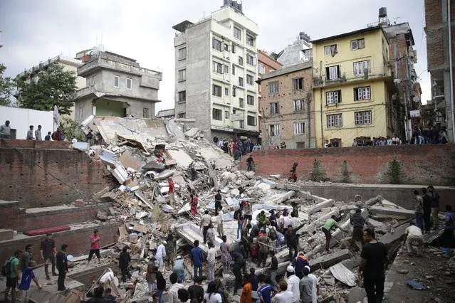 People search for survivors stuck under the rubble of a destroyed building, after an earthquake caused serious damage in Kathmandu, Nepal, 25 April 2015. (Photo by Narendra Shrestha/EPA)