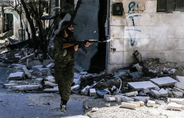 A Kurdish militia member in the Sheikh Maqsoud neighborhood in the city of Aleppo, Syria following rocket attacks on March 8, 2016. (Photo by TASS/Barcroft Media)