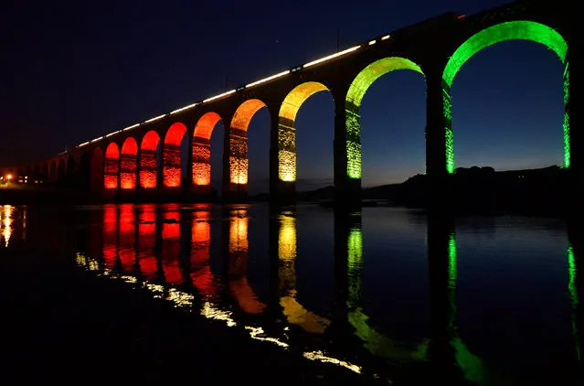 A train travelling on the East Coast mainline is reflected in the River Tweed as it crosses the Royal Border Bridge at dusk, in Berwick-Upon-Tweed in Northumberland, Britain August 22, 2013. (Photo by Toby Melville/Reuters)