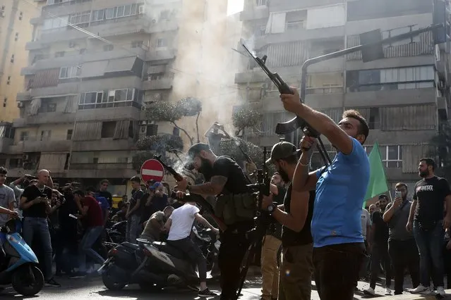 Supporters of the Shiite Amal group fire weapons in the air during the funeral processions of Hassan Jamil Nehmeh, who was killed during yesterday clashes, in the southern Beirut suburb of Dahiyeh, Lebanon, Friday, October 15, 2021. (Photo by Bilal Hussein/AP Photo)