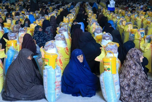 Afghan women receive food from a local charity during the Islamic holy fasting month of Ramadan on March 18, 2024. (Photo by Mohsen Karimi/AFP Photo)