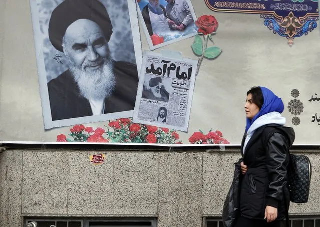 Iranians walk past a picture of Iranian late supreme leader Ayatollah Ruhollah Khomeini as the country marks the 45th anniversary of Khomeini's return from his Paris exile, in Tehran, Iran, 01 February 2024. Iran will celebrate its 45th revolution anniversary on 11 February 2024. (Photo by Abedin Taherkenareh/EPA/EFE)
