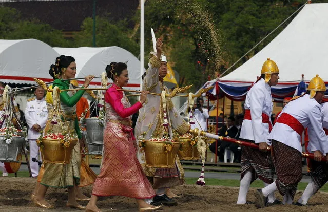 Chavalit Chookajorn, permanent secretary of the Thai Ministry of Agriculture and Cooperatives, dressed in a traditional costume, throws rice grains during the annual royal ploughing ceremony in central Bangkok, Thailand, May 13, 2015. The ancient ploughing ceremony in Buddhist Thailand, overseen by Thailand's Crown Prince Maha Vajiralongkorn, marks the end of the dry season and is meant to herald an auspicious start for the rice-planting season. (Photo by Chaiwat Subprasom/Reuters)