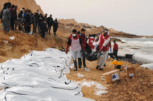 A handout picture released on February 21, 2017 by the Al-Zawiyah Branch of the Libyan Red Crescent shows Libyan Red Crescent volunteers recovering the bodies of 74 migrants that washed ashore on February 20 near Zawiyah on Libya's northern coast. The International Organization for Migration (IOM) said the boat was reported to have foundered leaving as many as 100 people dead. The agency said that if confirmed, the deaths would bring the total number of migrants killed trying to cross the Mediterranean so far this year to more than 365. (Photo by Al-Zawiyah Branch/AFP Photo/Libyan Red Crescent)
