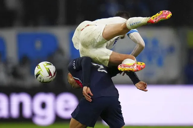 Marseille's Quentin Merlin jumps over PSG's Achraf Hakimi during the French League One soccer match between Marseille and Paris at the Velodrome stadium in Marseille, south of France, Sunday, March 31, 2024. (Photo by Daniel Cole/AP Photo)