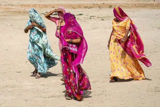 Women walk towards a polling station to cast their ballot during the first phase of voting for the India's general elections in Parbatsar in Rajasthan, on April 19, 2024. (Photo by Himanshu Sharma/AFP Photo)