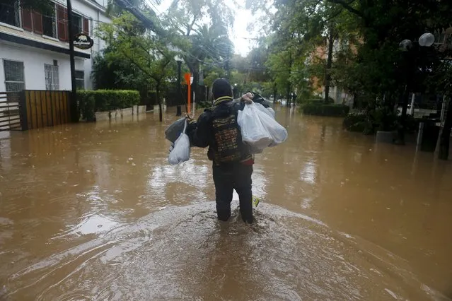 A man walks along a flooded street in Santiago, April 17, 2016. (Photo by Ivan Alvarado/Reuters)