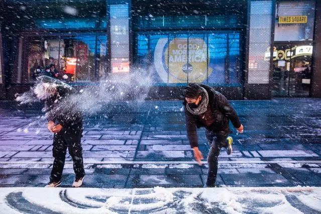 People play with snow as snow begins to fall in Times Square during a snow storm, during the coronavirus disease (COVID-19) pandemic in the Manhattan borough of New York City, New York, U.S., January 31, 2021. (Photo by Jeenah Moon/Reuters)