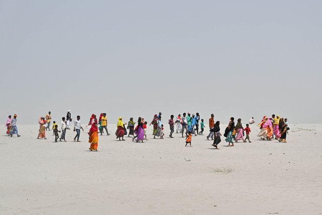 People travel towards a polling station to cast their ballot during the second phase of voting of India's general election at Gashbari village in Darrang district of Assam state on April 26, 2024. (Photo by Biju Boro/AFP Photo)