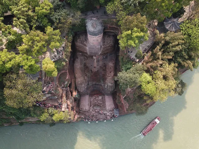 The giant statue of Buddha in Leshan, southwest China's Sichuan Province was reopened to visitors in early April 2019 after undergoing repairs over the past six months. Standing at 71 meters tall at the confluence of three rivers, it is believed to be the world's tallest stone Buddha statue. It was carved out of a cliff face of Cretaceous red sandstone. It was its ninth large-scale repairs since 1949. The removal of the scaffolding is expected to complete by the end of March. (Photo by Imaginechina/Shutterstock)