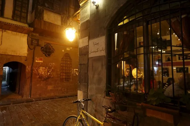 A bicycle is parked outside La Marionnette Pub in Damascus, Syria, March 11, 2016. (Photo by Omar Sanadiki/Reuters)