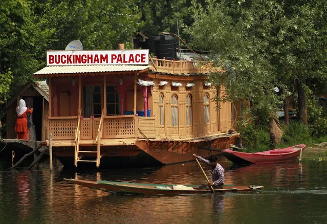 A Kashmiri man rows a Shikara in front of a houseboat named “Buckingham Palace” on the waters of Dal Lake in Srinagar June 13, 2012. (Photo by Fayaz Kabli/Reuters)