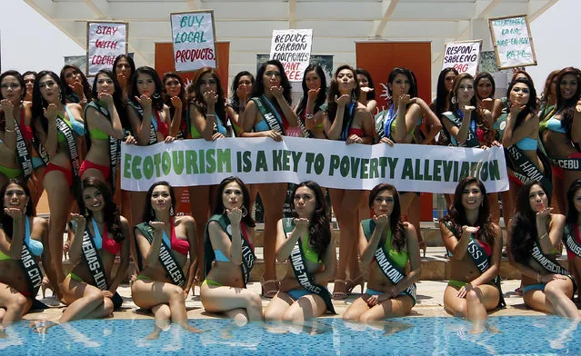 Filipino candidate's of the Miss Earth-Philippines beauty pageant hold placards to mark Earth Day at the Solaire Resort and Casino in Manila, Philippines, April 22, 2014. A total of 51 environmentally aware and concerned Filipino young ladies will compete to represent the Philippines at the Miss Earth beauty pageant. Now in its fourteenth year, Miss Earth is a pioneering beauty pageant that serves as a vehicle for environmental advocacy. Coronation night will be on May 11. (Photo by Ritchie B. Tongo/EPA)