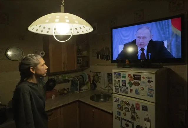 A woman watches TV with Russian President Putin speaking during a broadcast of a meeting of the National Security Council on the recognition of the self-proclaimed Donetsk People's Republic (DPR) and the Luhansk People's Republic (LPR), in St. Petersburg, Russia, 21 February 2022. Putin said he was considering a request from leaders of the two self-proclaimed republics to recognise them as independent states, less than a week after the Duma on 15 February voted to appeal to President Putin to recognise the two Donbas regions. The regions declared independence in 2014 amid an armed conflict in the eastern Ukraine. (Photo by Anatoly Maltsev/EPA/EFE)