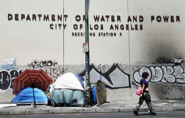 A person walks past an encampment of homeless people in the Skid Row community on July 25, 2024 in Los Angeles, California. California Governor Gavin Newsom issued an executive order for state officials to begin dismantling encampments of Californians who are homeless on the heels of a recent Supreme Court decision. (Photo by Mario Tama/Getty Images)