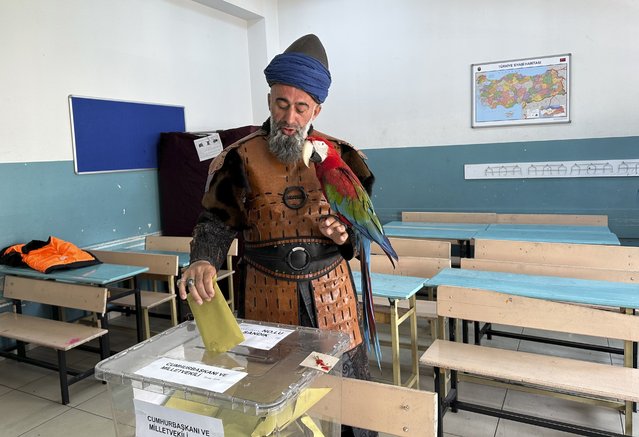 Nazim Cihan, 48, holds his bird as he votes at a polling station in Istanbul, Turkey, Sunday, May 14, 2023. Voters in Turkey go to the polls on Sunday for pivotal parliamentary and presidential elections that are expected to be tightly contested and could be the biggest challenge Turkish President Recep Tayyip Erdogan faces in his two decades in power. (Photo by iHA via AP Photo)