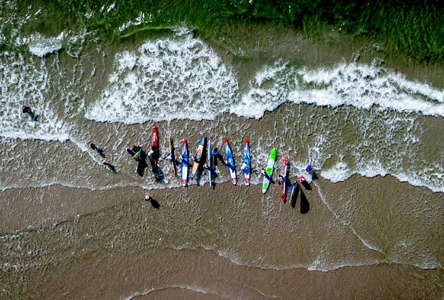 Competitors prepare for a stand-up paddle race on the German island of Fehmarn on Sunday, July 14, 2024. (Photo by Michael Probst/AP Photo)