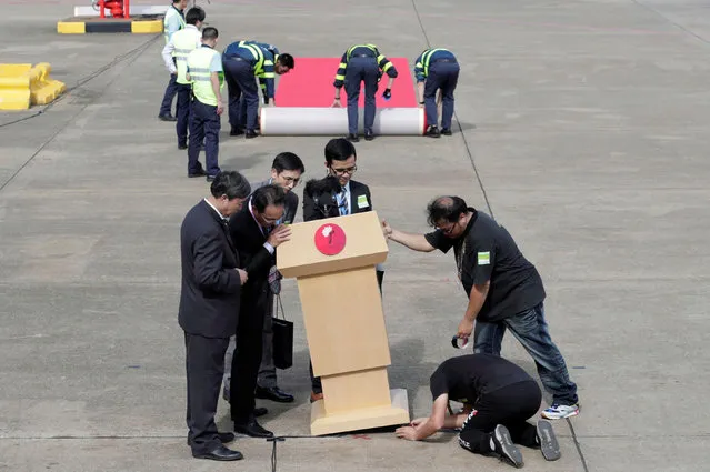 Staff members set up lectern and red carpet before Chinese President Xi Jinping's arrival at Macau International Airport in Macau, China on December 18, 2019, ahead of the 20th anniversary of the former Portuguese colony's return to China. (Photo by Jason Lee/Reuters)
