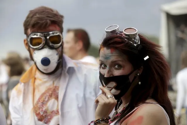 People wear protection masks as they attend the Holi festival, or the Festival of Colors, in Riga, Latvia, August 1, 2015. (Photo by Ints Kalnins/Reuters)