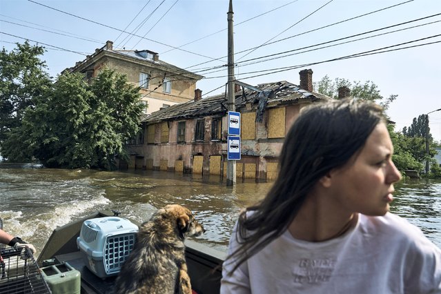 A Local resident with her pets are evacuated on a boat from a flooded neighbourhood in Kherson, Ukraine, Thursday, June 8, 2023. Floodwaters from a collapsed dam kept rising in southern Ukraine on Thursday, forcing hundreds of people to flee their homes in a major emergency operation that brought a dramatic new dimension to the war with Russia, now in its 16th month. (Photo by Libkos/AP Photo)