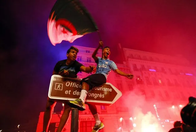 Algerian soccer fans celebrate after their team qualified for the World Cup, in Marseille, southern France, on June 26, 2014. Algeria drew with Russia 1-1, and advanced to the round of 16 for the first time in their World Cup history. (Photo by Claude Paris/Associated Press)