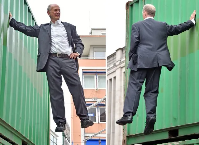 A combination of two pictures taken on August 1, 2015 in Karlsruhe, southwestern Germany shows German artist Johan Lorbeer clinging at a container during the performance “Tarzan/Standbein” (Tarzan/Supporting leg) during the open air exhibition “The city is the star, Art at the construction site” that runs until September 27, 2015. (Photo by Uli Deck/AFP Photo/DPA)