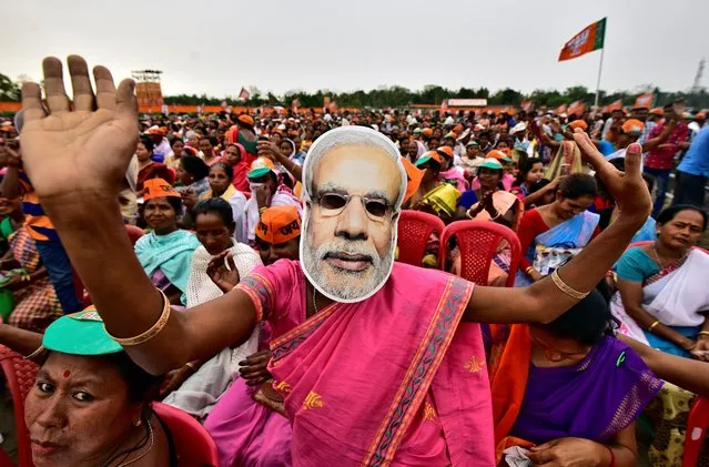 A woman wearing a mask of Prime Minister Narendra Modi dances as she attends an election campaign rally being addressed by Bharatiya Janata Party (BJP) President Amit Shah at Ahatguri village in Morigaon district in the northeastern state of Assam, April 5, 2019. (Photo by Anuwar Hazarika/Reuters)