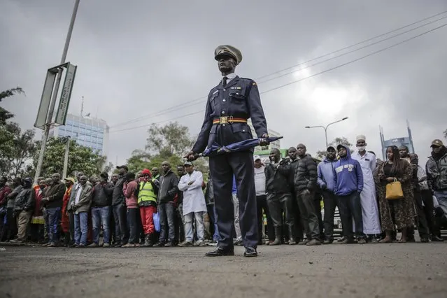 A policeman observes the procession at the state funeral of Kenya's former President Mwai Kibaki, in the capital Nairobi, Kenya Friday, April 29, 2022. Kenyans are paying their last respects to the former leader, whose death was announced last Friday, in a state funeral service that is attended by African leaders. (Photo by Brian Inganga/AP Photo)
