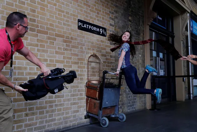 A woman poses for a photograph with the Harry Potter trolley at Kings Cross Station, in London, Britain June 26, 2017. The first Harry Potter book, “Harry Potter and the Philosopher's Stone” was first published 20 years ago. (Photo by Eddie Keogh/Reuters)