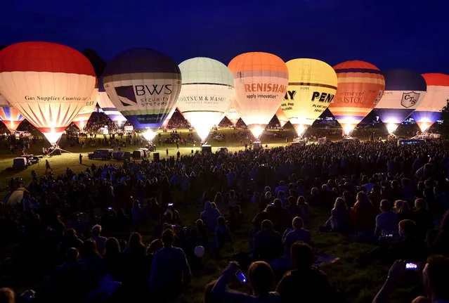 Balloons are illuminated by their burners during a dusk display at the Bristol International balloon fiesta in south west England August 6, 2015. (Photo by Toby Melville/Reuters)