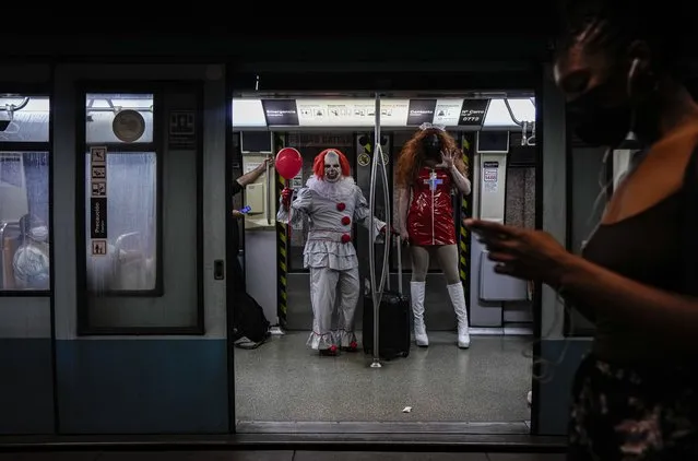 People in Halloween costumes travel on the subway in Santiago, Chile, Sunday, October 31, 2021. (Photo by Esteban Felix/AP Photo)