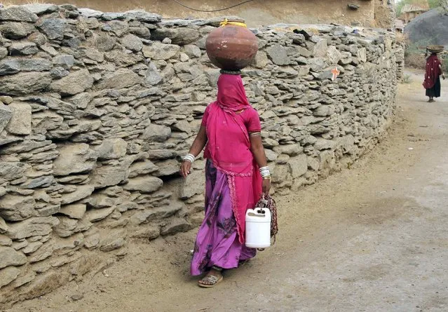 A woman carries a pitcher filled with drinking water in Devmali village in the desert state of Rajasthan, India, June 16, 2016. (Photo by Himanshu Sharma/Reuters)